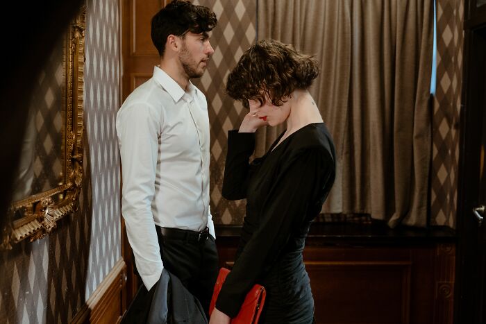 Upset woman and concerned man in emotional confrontation indoors