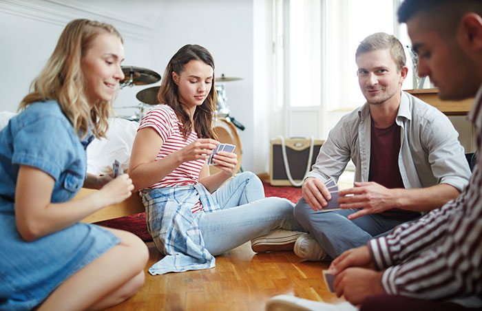 Four friends playing cards on the floor, smiling. A guy needs a GF and weight-loss coach, and his model friend is not having it. Four friends playing cards on the floor, smiling. A guy needs a GF and weight-loss coach, and his model friend is not having it.