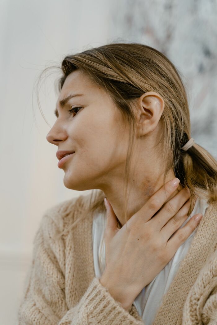 Woman with sore throat touching her neck