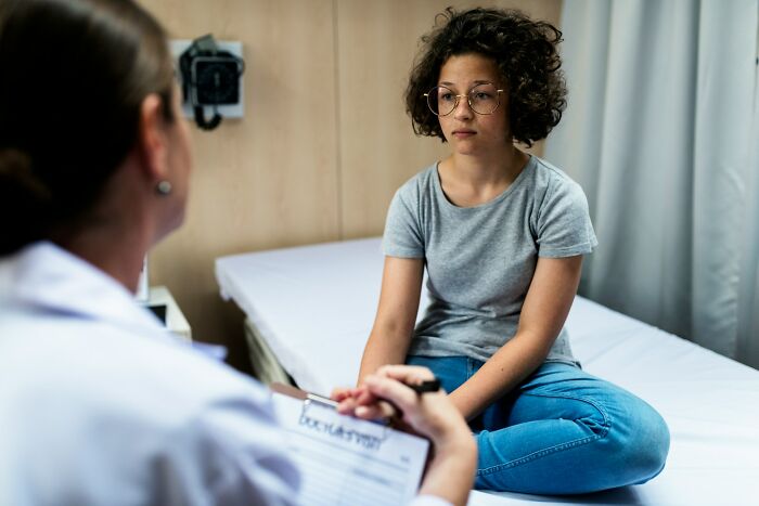 Woman consulting doctor showing sexist treatment in healthcare setting