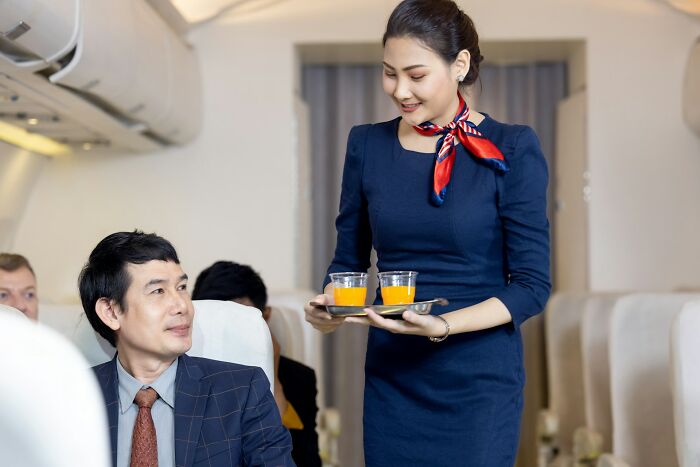 Woman flight attendant serving drinks highlighting sexist treatment