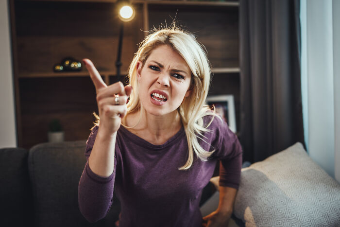 An angry woman points her finger, expressing anger and marriage regrets during a fight