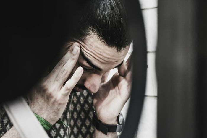 A frustrated client holding their head in their hands, conveying the stress of dealing with lawyers over stupid mistakes.