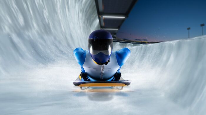 A skeleton athlete racing down an ice track, demonstrating satisfying stories of focus and speed.