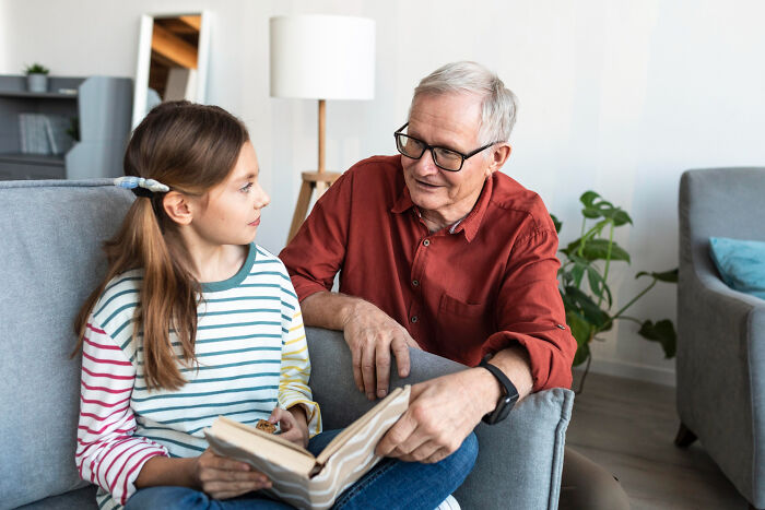 A young girl with long hair reading a book with an older man. Unsettling stories from small towns can reveal shocking secrets.