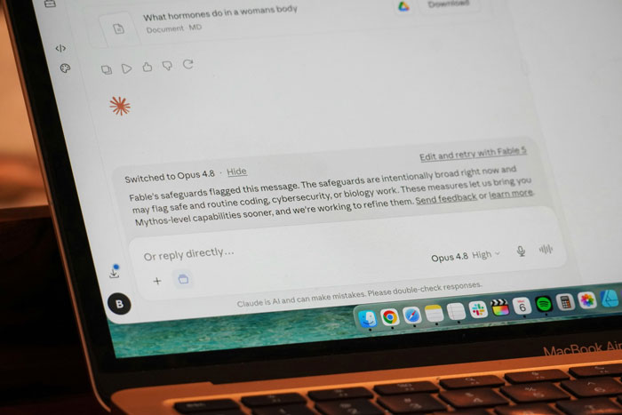 A laptop screen displaying an AI chat interface and a warning message about AI safeguards. A laptop screen displaying an AI chat interface and a warning message about AI safeguards.