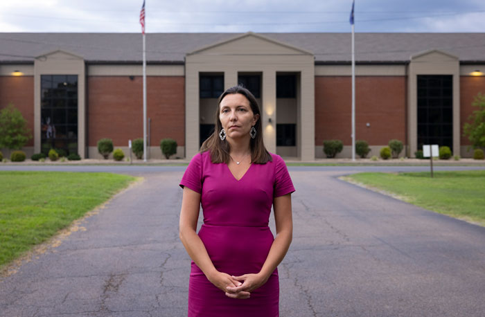 Woman in a magenta dress in front of a school, related to Stephen King's pulled book. Woman in a magenta dress in front of a school, related to Stephen King's pulled book.