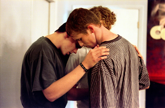 Three young men embracing, a scene reflecting themes from Stephen King's pulled book publication. Three young men embracing, a scene reflecting themes from Stephen King's pulled book publication.