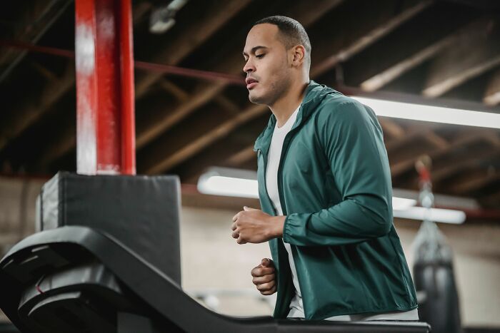 Man running on treadmill inside a home gym
