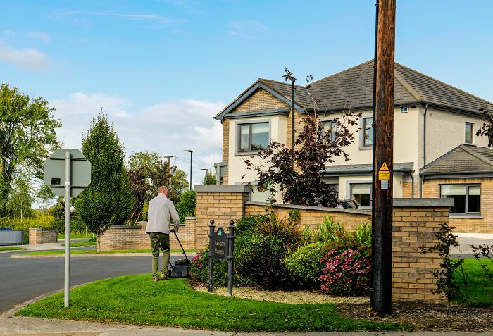 Man mowing lawn outside a residential home, illustrating weird things people were not prepared to see.