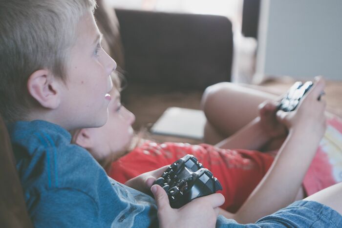 Children playing video games at home holding controllers