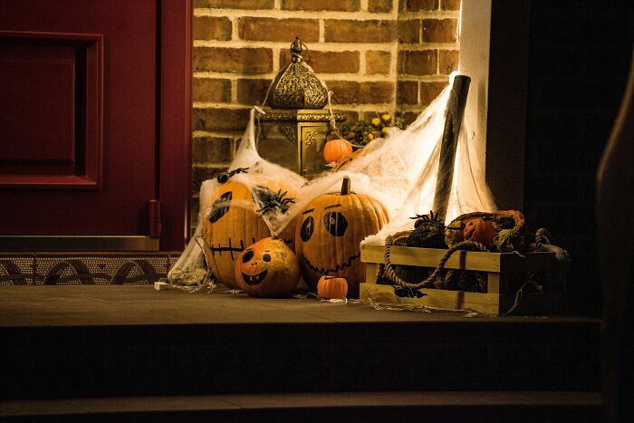 Weird Halloween decorations outside a home including carved pumpkins and fake spiderwebs. Things not prepared to see.