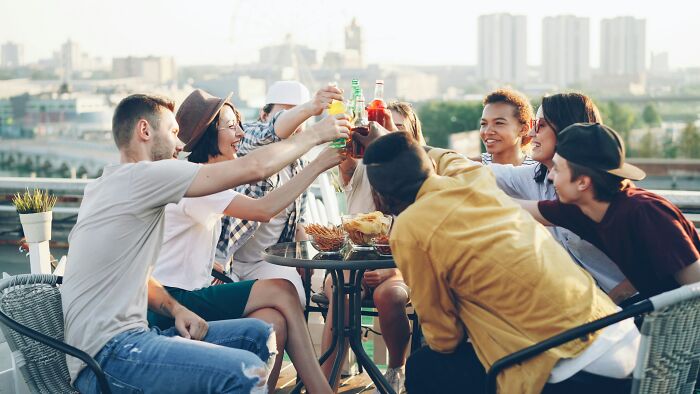 A group of young adults toasting, possibly before one brushes off sepsis symptoms as a bad hangover.