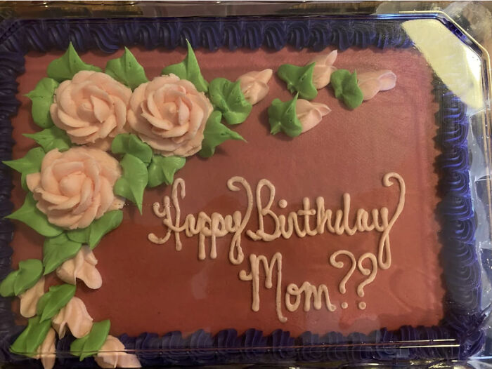 A rectangular cake with pink roses and green leaves, inscribed with Happy Birthday Mom??, showing mischievous kids.