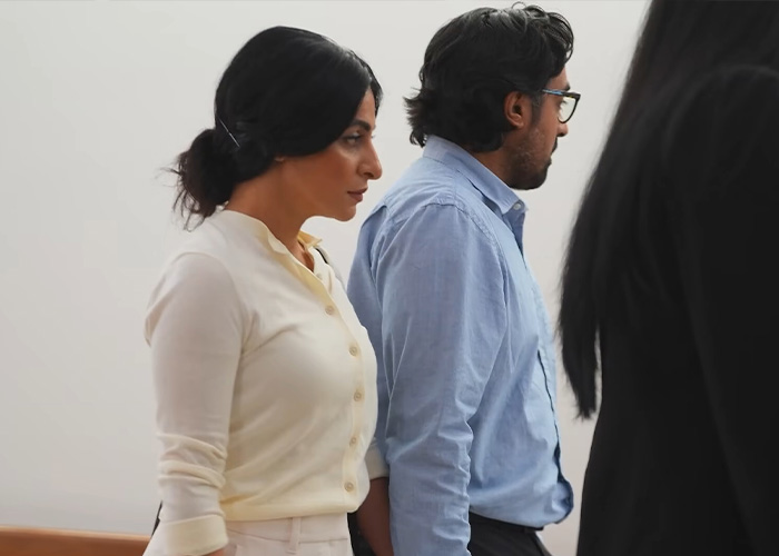 The child's biological parents, a man and a woman, standing in a hallway, connected to the surrogate who refused to end the pregnancy. The child's biological parents, a man and a woman, standing in a hallway, connected to the surrogate who refused to end the pregnancy.