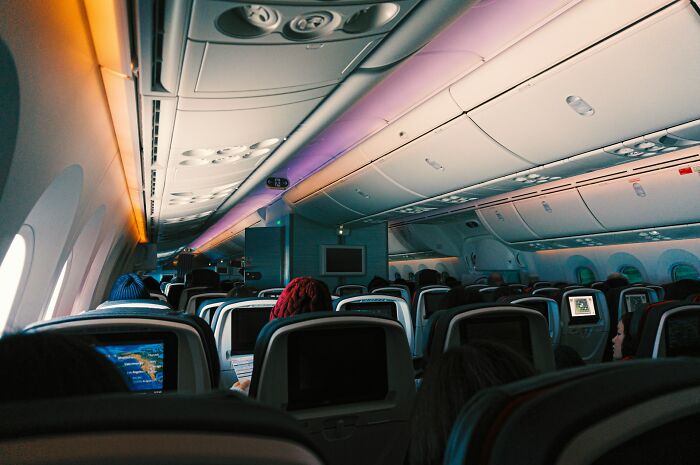 Passengers seated inside an airline cabin, illustrating an airline seating lottery nightmare story.