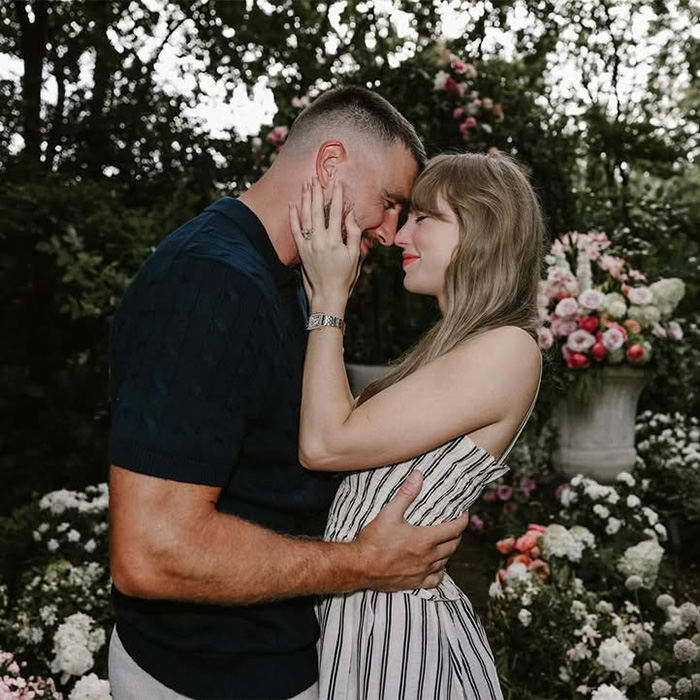 Taylor Swift and Travis Kelce embracing closely in a garden filled with lush white and pink flowers Taylor Swift and Travis Kelce embracing closely in a garden filled with lush white and pink flowers