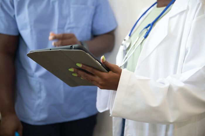Medical professional holding a tablet, discussing a health scare, possibly related to a teen's vaping habit. Medical professional holding a tablet, discussing a health scare, possibly related to a teen's vaping habit.