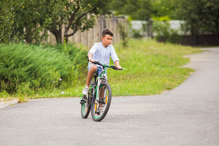 Young boy riding a bicycle on a path outdoors