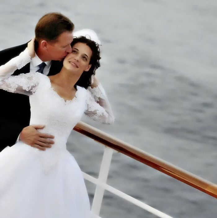 A couple in wedding attire embracing on a cruise ship deck during their anniversary trip. A couple in wedding attire embracing on a cruise ship deck during their anniversary trip.