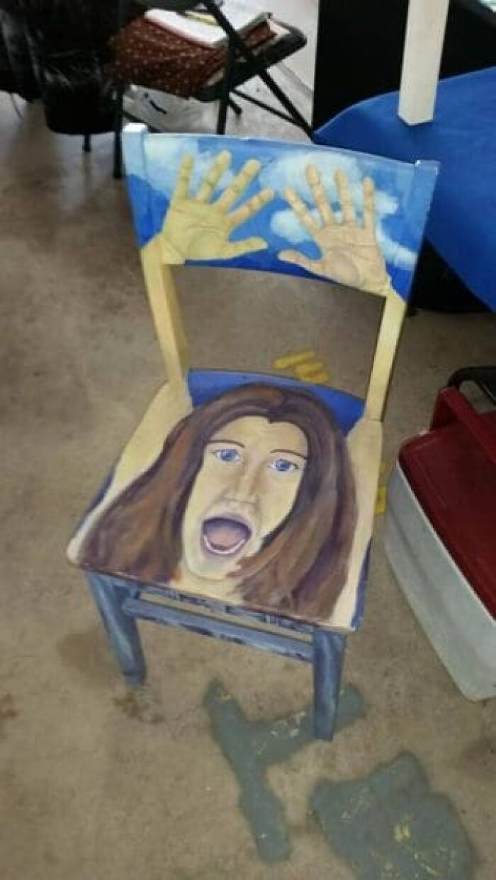 A chair painted with a screaming face and hands, an example of unhinged secondhand finds.