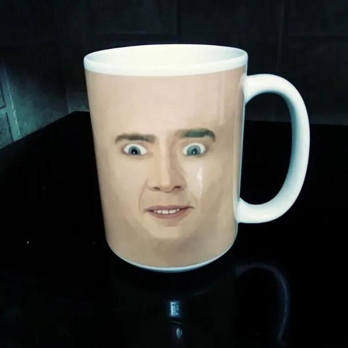 A coffee mug featuring Nicolas Cage's face, an unhinged secondhand find for cursed treasure.