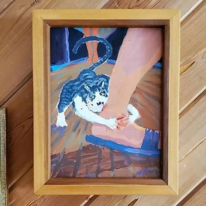Painting of a cat attacking a person's foot, a truly unhinged secondhand find.