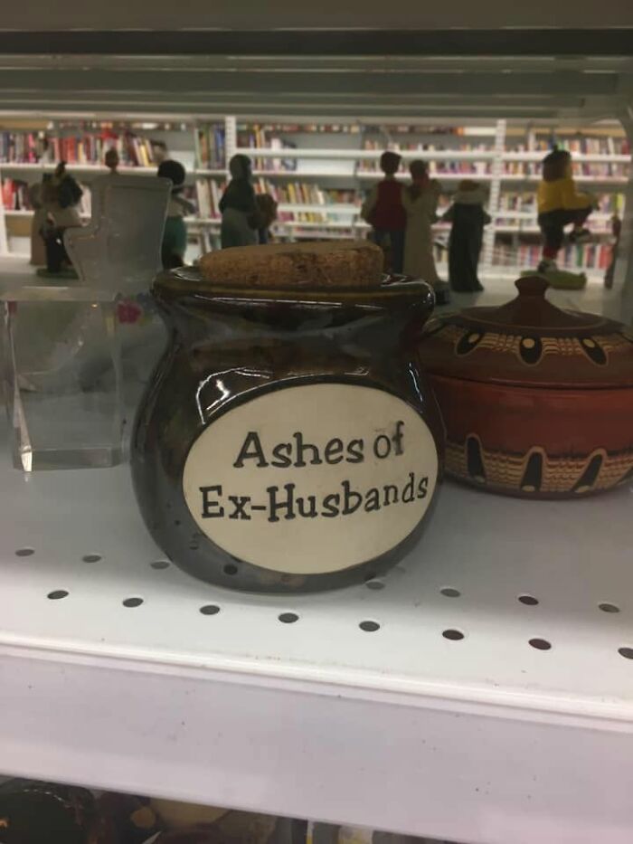 Unhinged secondhand finds: A ceramic jar labeled Ashes of Ex-Husbands on a shelf in a store.