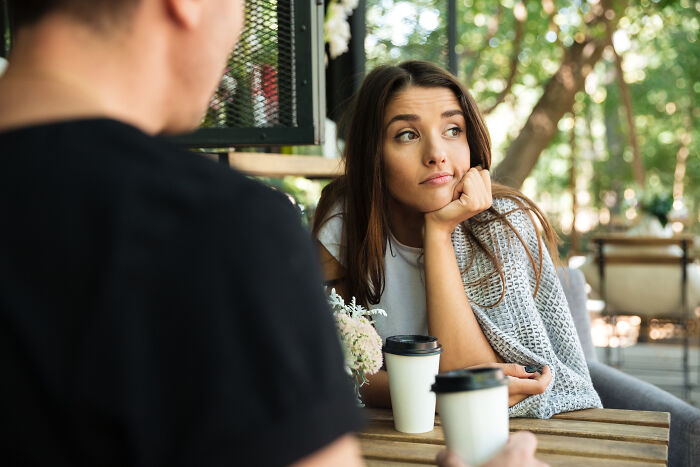 A woman looking displeased at her date, highlighting common dating red flags and unserious dating situations.
