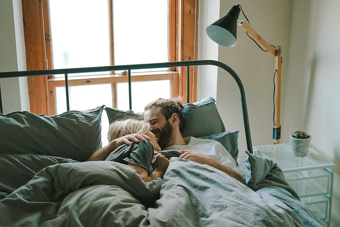 A couple sharing a loving moment in bed, symbolizing weddings and romance