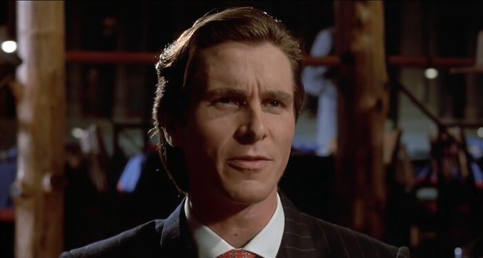 Christian Bale as Patrick Bateman in a dark suit, sharing new facts
