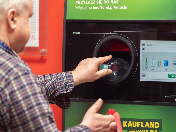 A man recycling plastic bottle at a machine, sharing new facts