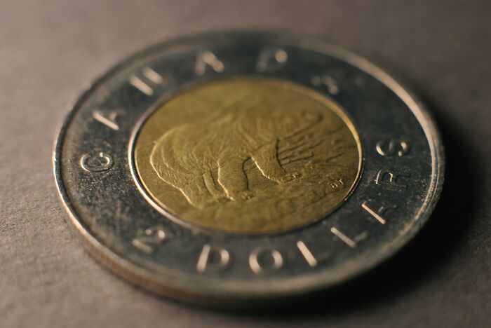 A close-up shot of a Canadian two-dollar coin, showing new facts on currency design and history