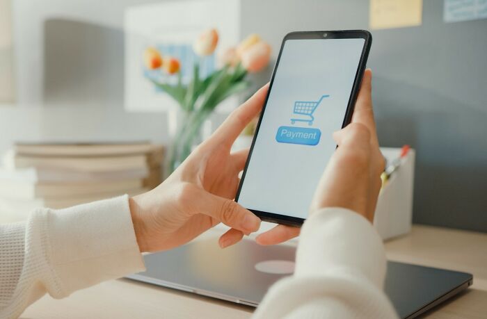 A person using a smartphone to make an online payment, showcasing new facts about digital habits