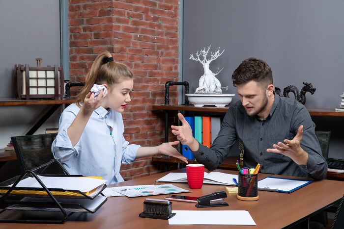 Two office workers arguing over a mistake that speaks for itself in a tense meeting.