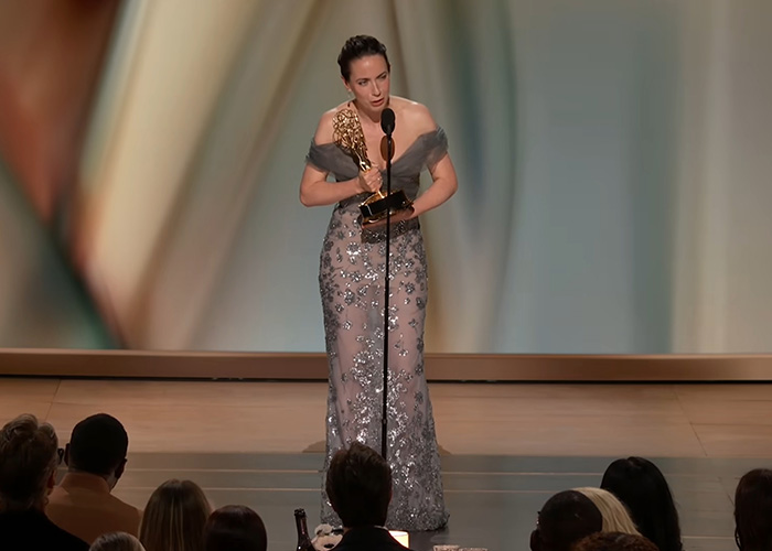 A woman in a gown holding an Emmy award on stage, reflecting on the alarming trend amongst Emmy Winners. A woman in a gown holding an Emmy award on stage, reflecting on the alarming trend amongst Emmy Winners.