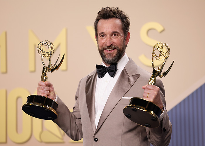 A happy Emmy winner holds two Emmy awards, posing for the camera at the Emmys event. A happy Emmy winner holds two Emmy awards, posing for the camera at the Emmys event.