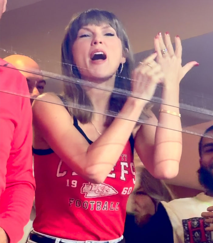 Taylor Swift in a Chiefs tank top cheering for Travis Kelce at a football game Taylor Swift in a Chiefs tank top cheering for Travis Kelce at a football game