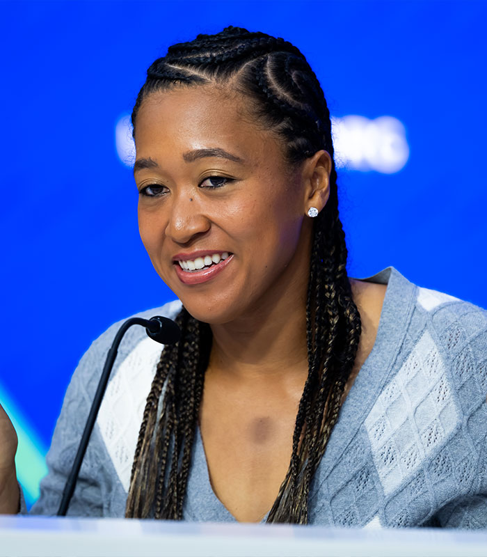 Naomi Osaka, one of the US Open influencers, is smiling at a press conference. Naomi Osaka, one of the US Open influencers, is smiling at a press conference.