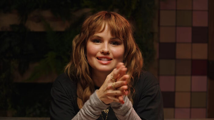 Debby Ryan smiling and holding her hands together, discussing celebrity encounters.