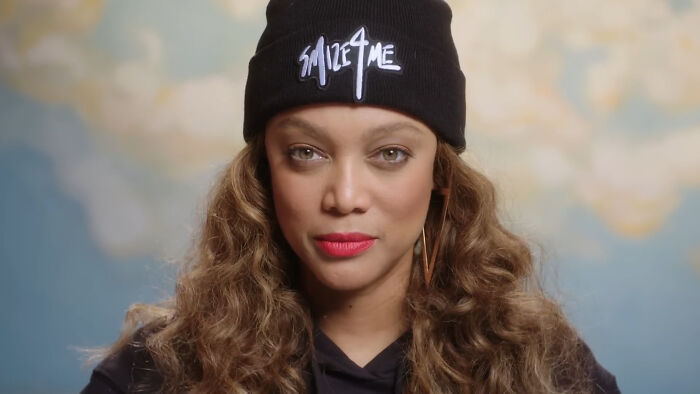 Tyra Banks wearing a black Smize for Me beanie, posing for a portrait about celebrity encounters.
