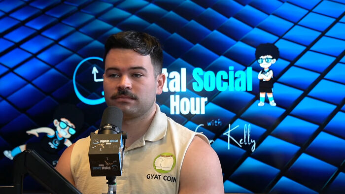 Man with mustache speaking into microphone during digital social livestream