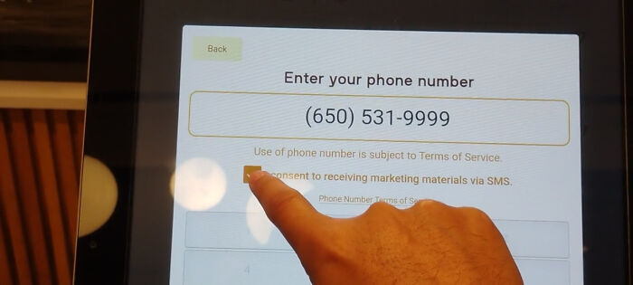 An on-screen prompt requiring SMS marketing consent to proceed, an example of terrible product design.
