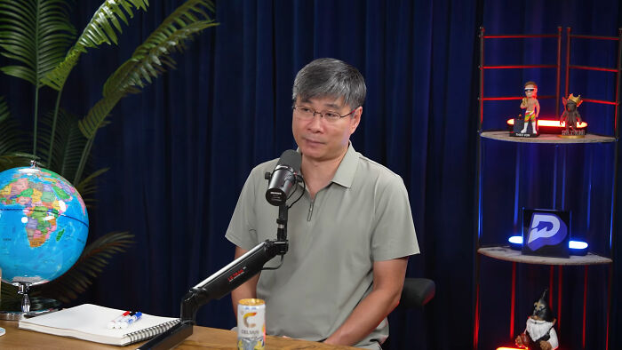 Chinese Nostradamus discussing predictions for 2027 in a podcast studio.