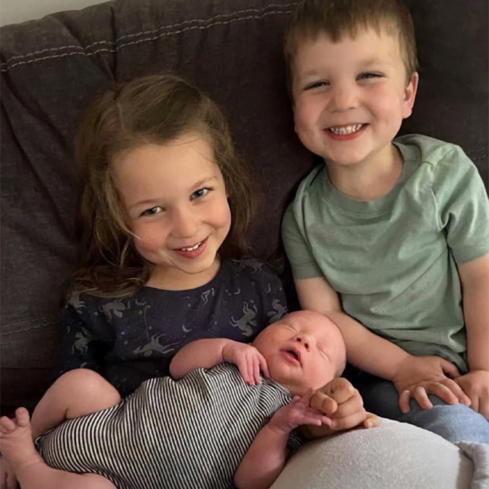 Two older children smiling with a newborn baby, possibly Lindsay Clancy's children. Two older children smiling with a newborn baby, possibly Lindsay Clancy's children.