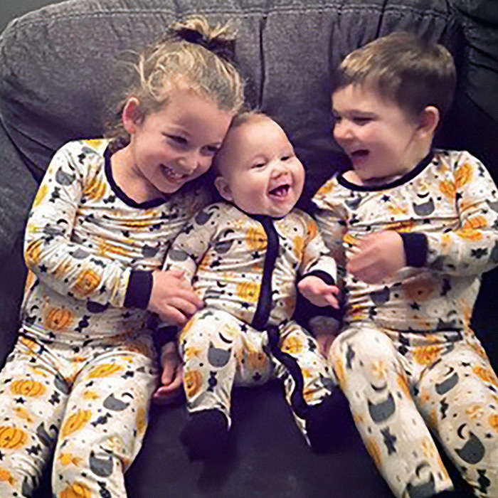 Three young children in matching Halloween-themed pajamas, possibly Lindsay Clancy's children. Three young children in matching Halloween-themed pajamas, possibly Lindsay Clancy's children.