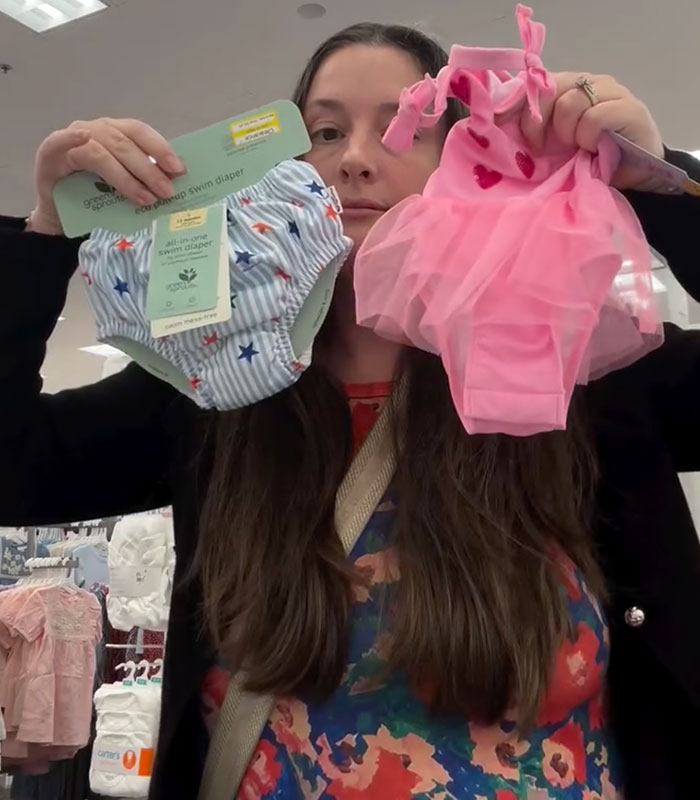 Viral mom holding a girls' t-shirt and swim diaper, addressing the controversial message on the t-shirt. Viral mom holding a girls' t-shirt and swim diaper, addressing the controversial message on the t-shirt.