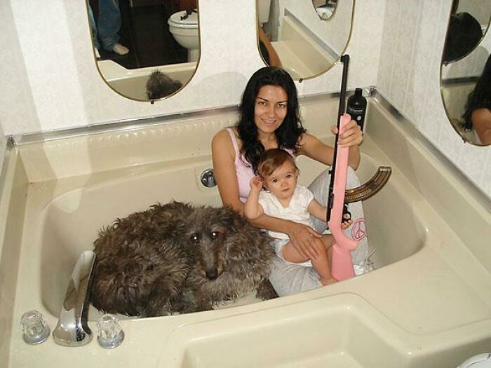 Unhinged images featuring a woman with a baby and a dog in a bathtub, holding a pink rifle.