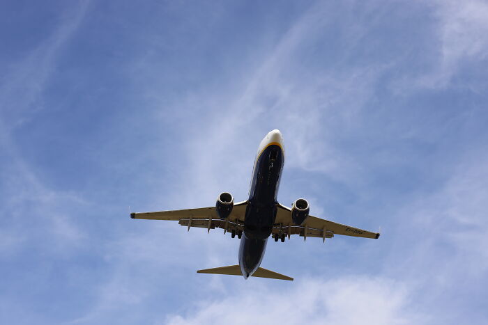 An airplane flying high in the sky, reflecting travel trends in today's economy.