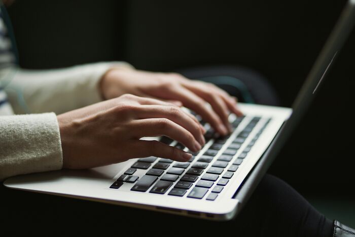 Close-up of hands typing on a laptop keyboard, highlighting digital work trends